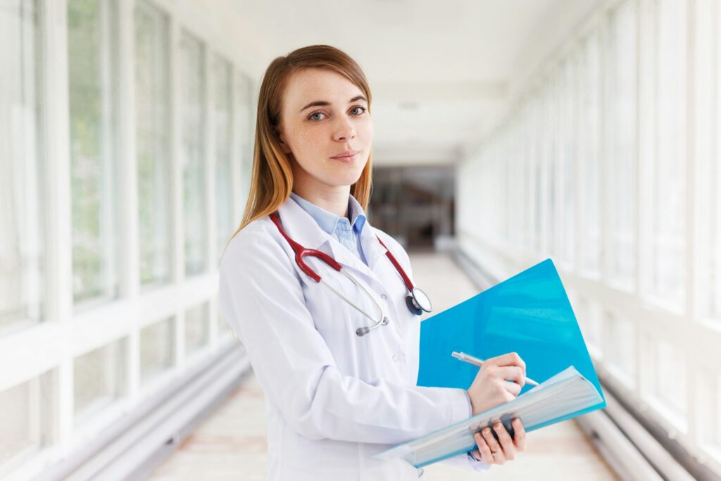 Young female medical doctor writing anamnesis in her folder