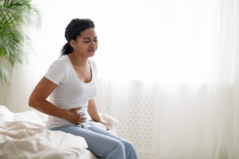 Dolor de estómago. Mujer enferma con dolor abdominal agudo en casa.